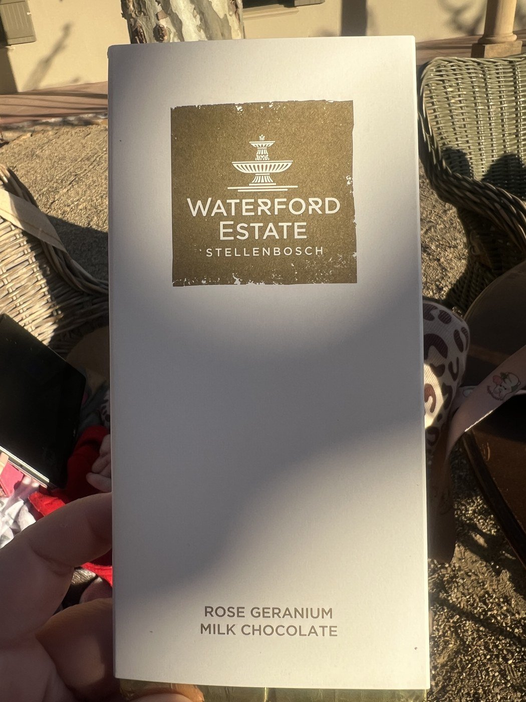 Barra de chocolate na embalagem branca do Waterford Estate Stellenbosch, com a escrita Rose Geranium Milk Chocolate embaixo